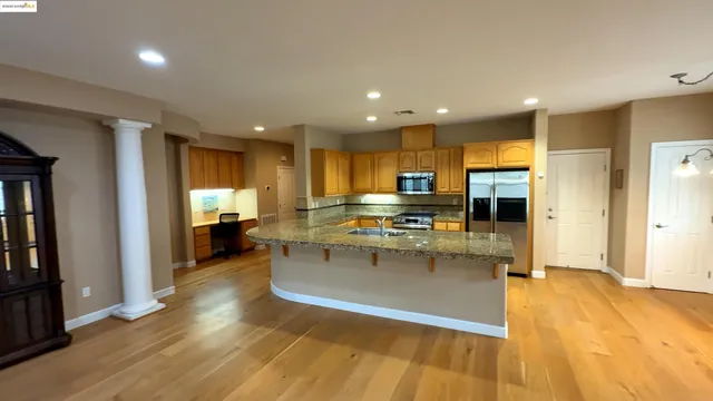 a kitchen with stainless steel appliances granite countertop a refrigerator and a stove top oven