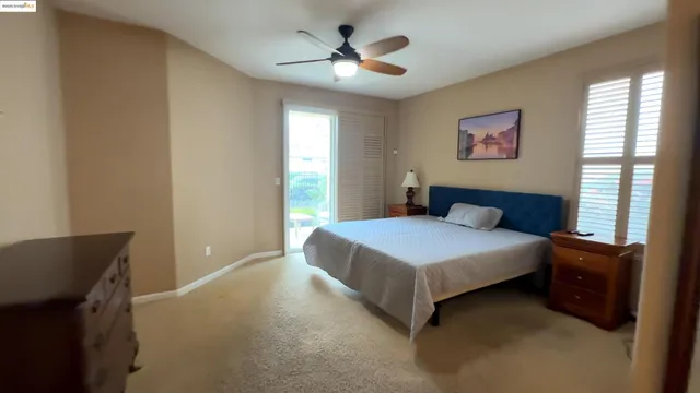 a bedroom with a bed and a ceiling fan