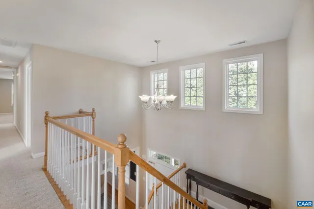 wooden floor with a chandelier and a workspace