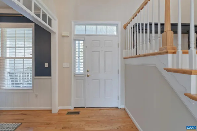 a bathroom with a toilet a sink a mirror and a window