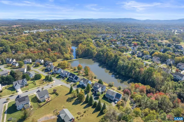 an aerial view of residential houses with outdoor space and trees