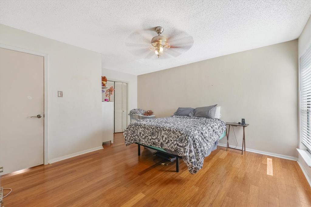 1301 Memory Lane, Unit 4924 Arlington, TX 76011 - Photo 11 of 19 Bedroom featuring a textured ceiling, light wood-style floors, a closet, and a ceiling fan