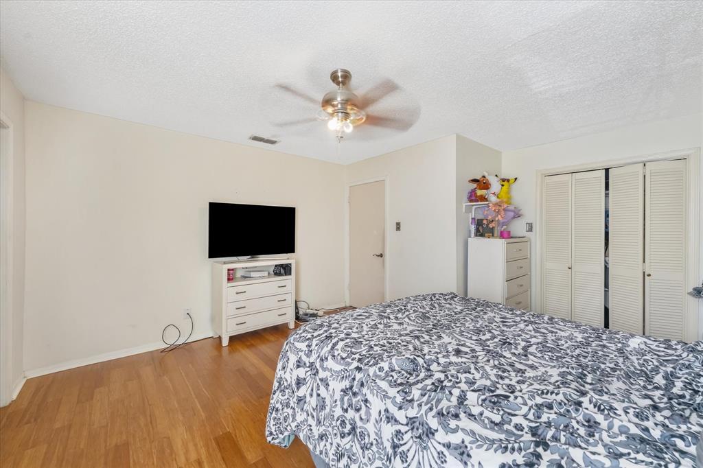 1301 Memory Lane, Unit 4924 Arlington, TX 76011 - Photo 12 of 19 Bedroom featuring a textured ceiling, a closet, light wood finished floors, and ceiling fan
