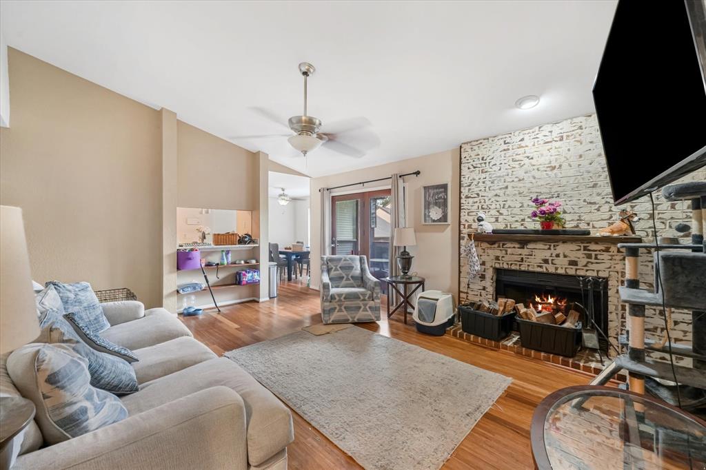 1301 Memory Lane, Unit 4924 Arlington, TX 76011 - Photo 2 of 19 Living area with wood finished floors, a fireplace, and a ceiling fan
