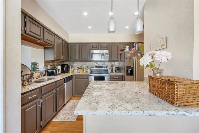 a large kitchen with stainless steel appliances kitchen island granite countertop a sink counter space and cabinets