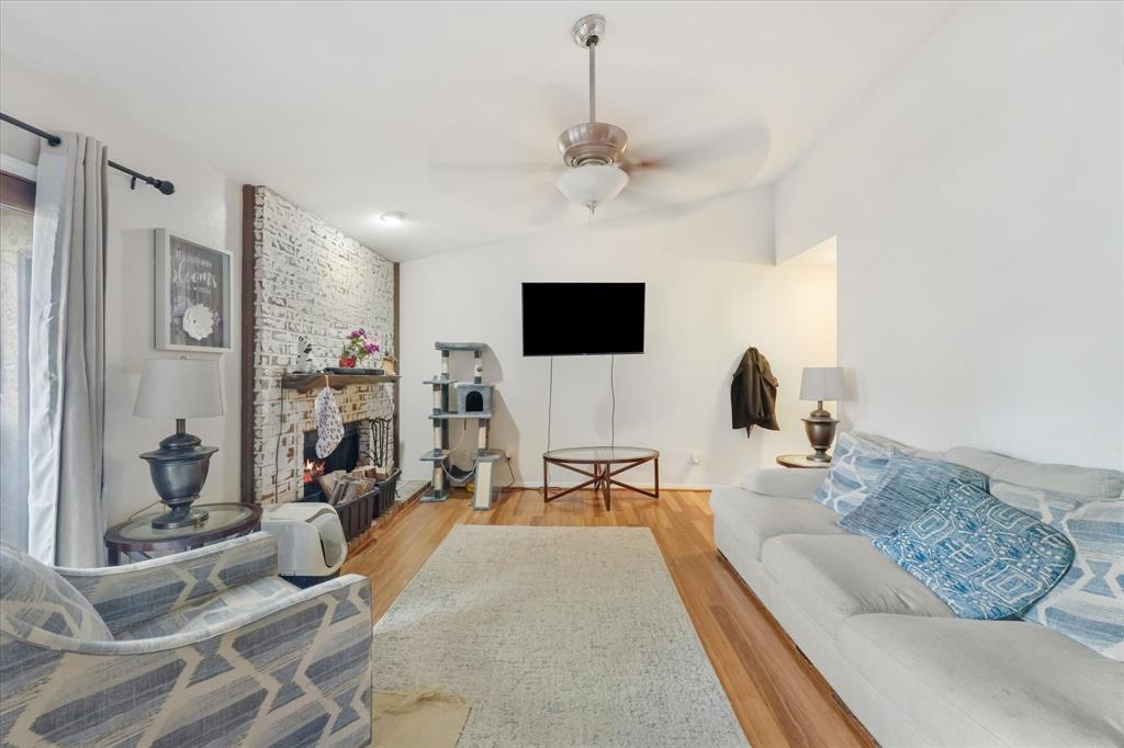 1301 Memory Lane, Unit 4924 Arlington, TX 76011 - Photo 6 of 19 Living room featuring ceiling fan, light wood-style flooring, a fireplace, and lofted ceiling