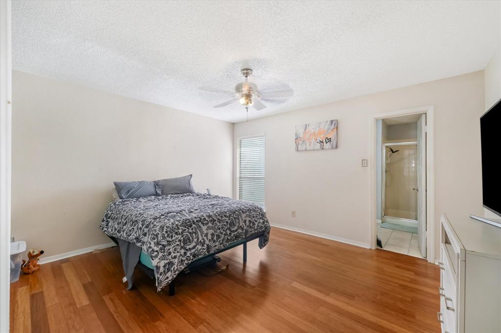 1301 Memory Lane, Unit 4924 Arlington, TX 76011 - Photo 10 of 19 Bedroom with a textured ceiling, light wood-type flooring, and a ceiling fan