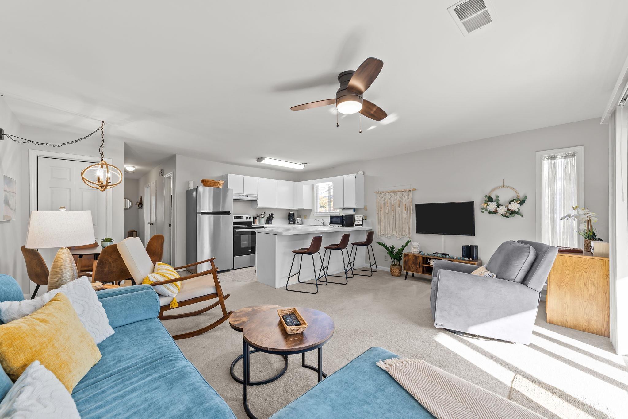 3700 Golf Colony Lane, Unit 2I Little River, SC 29566 - Photo 13 of 23 Living room with light colored carpet, ceiling fan, and a chandelier