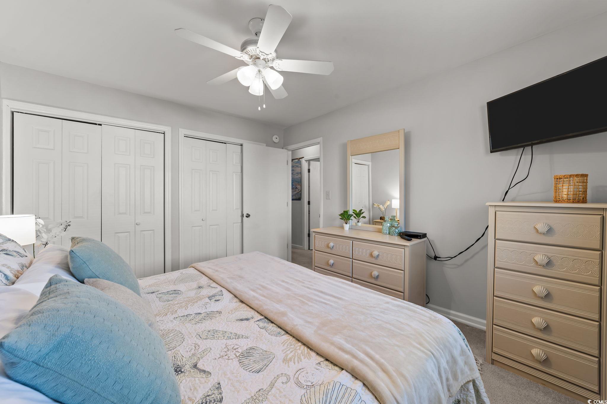 3700 Golf Colony Lane, Unit 2I Little River, SC 29566 - Photo 5 of 23 Bedroom featuring two closets, carpet flooring, and a ceiling fan