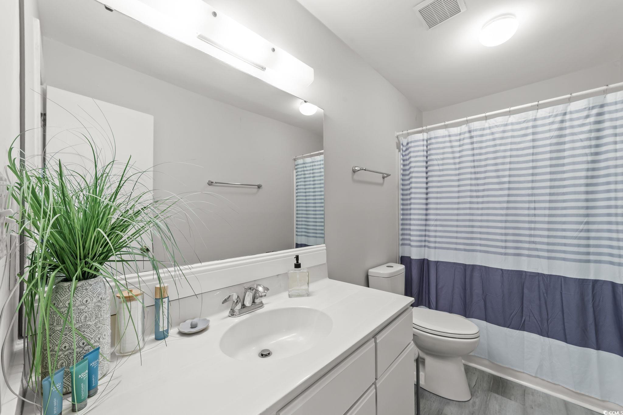 3700 Golf Colony Lane, Unit 2I Little River, SC 29566 - Photo 6 of 23 Bathroom featuring vanity, a shower with curtain, and wood finished floors