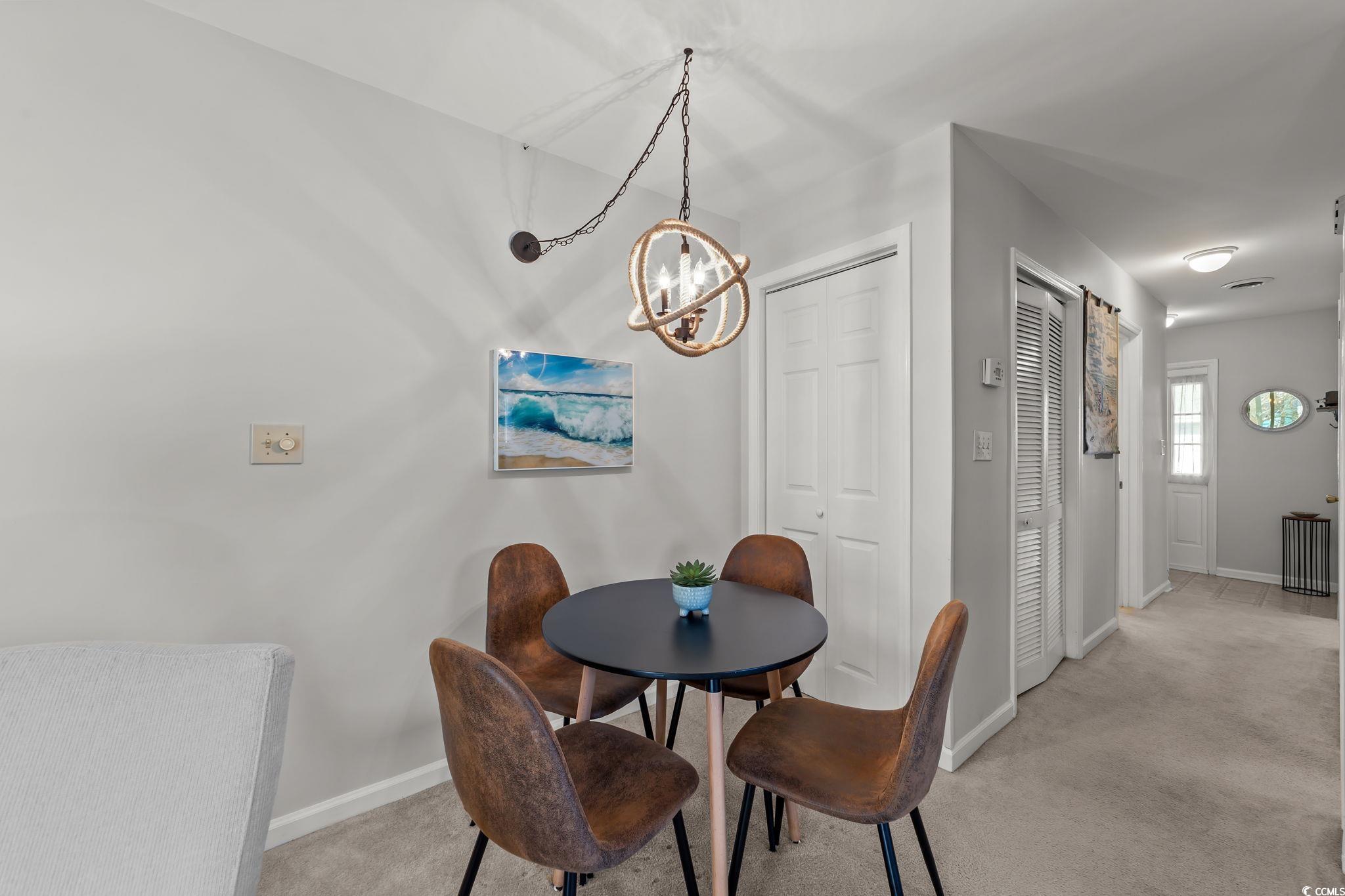 3700 Golf Colony Lane, Unit 2I Little River, SC 29566 - Photo 8 of 23 Dining area featuring light carpet and a chandelier