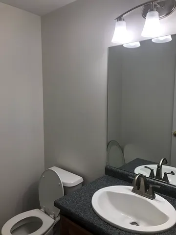 a bathroom with a toilet sink and mirror