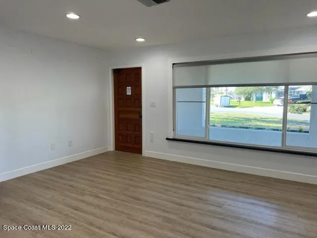an empty room with wooden floor and door