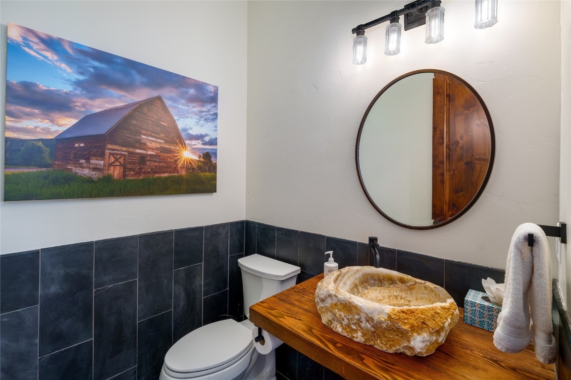 2669 Bronc Buster Loop Steamboat Springs, CO 80487 - Photo 21 of 49 a bathroom with a toilet mirror and vanity