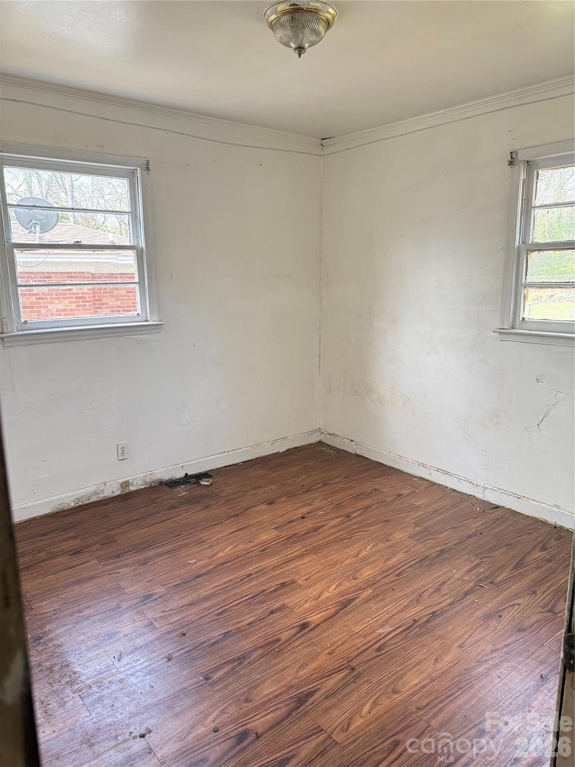 205 Jewel Street Chester, SC 29706 - Photo 9 of 20 an empty room with wooden floor and windows