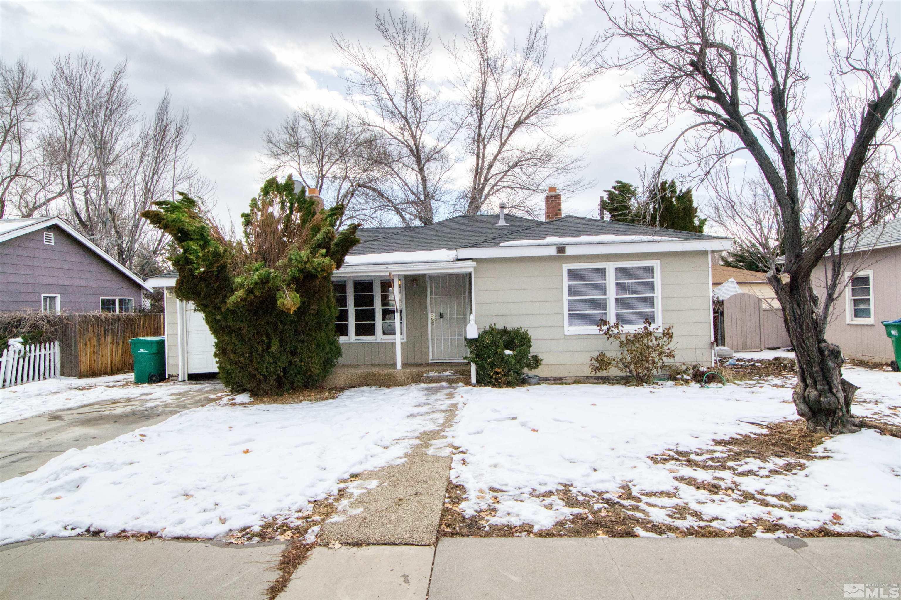 a front view of a house with a yard covered in snow