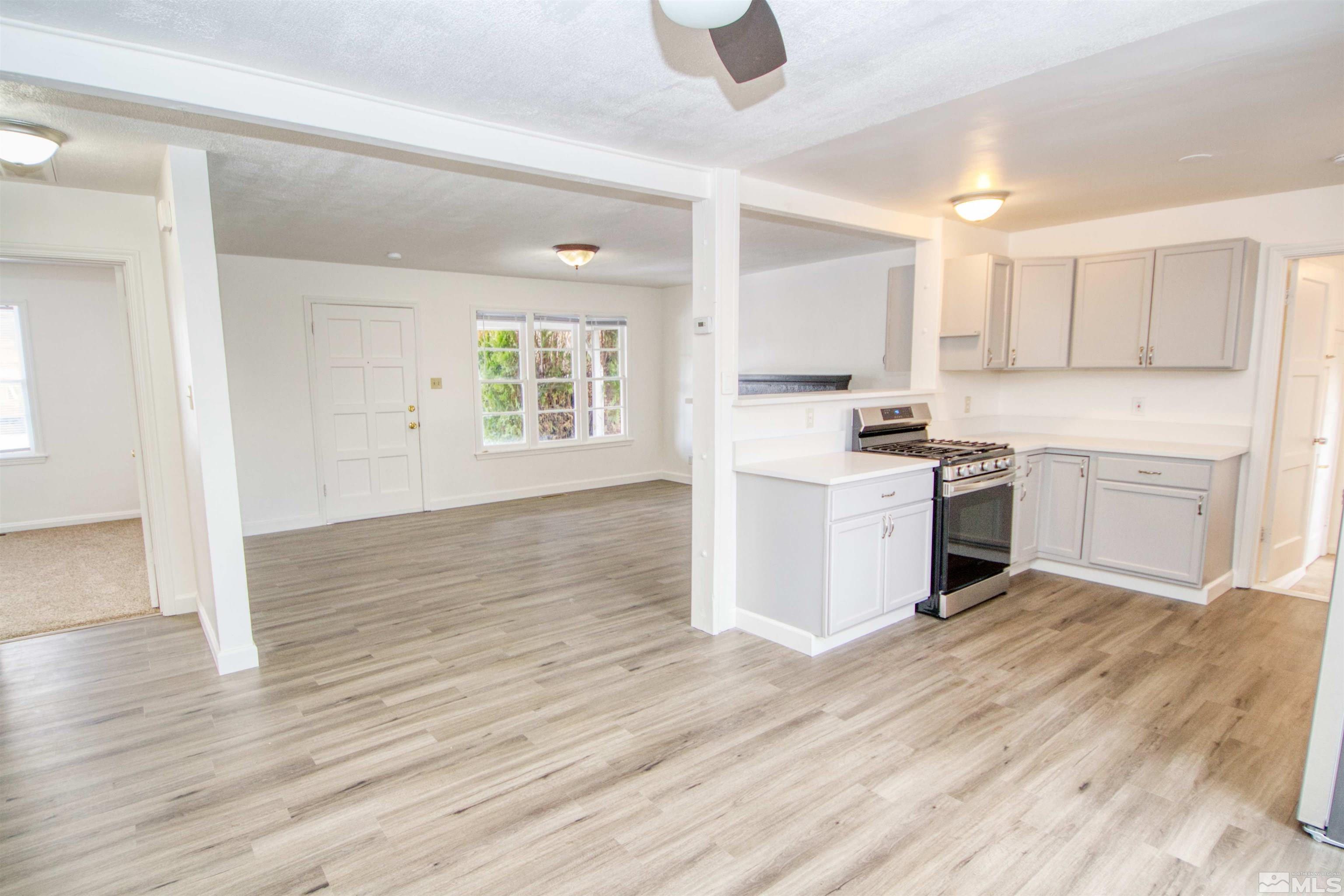 345 H Street Sparks, NV 89431 - Photo 4 of 17 a kitchen with stainless steel appliances granite countertop a stove top oven a sink dishwasher and white cabinets with wooden floor