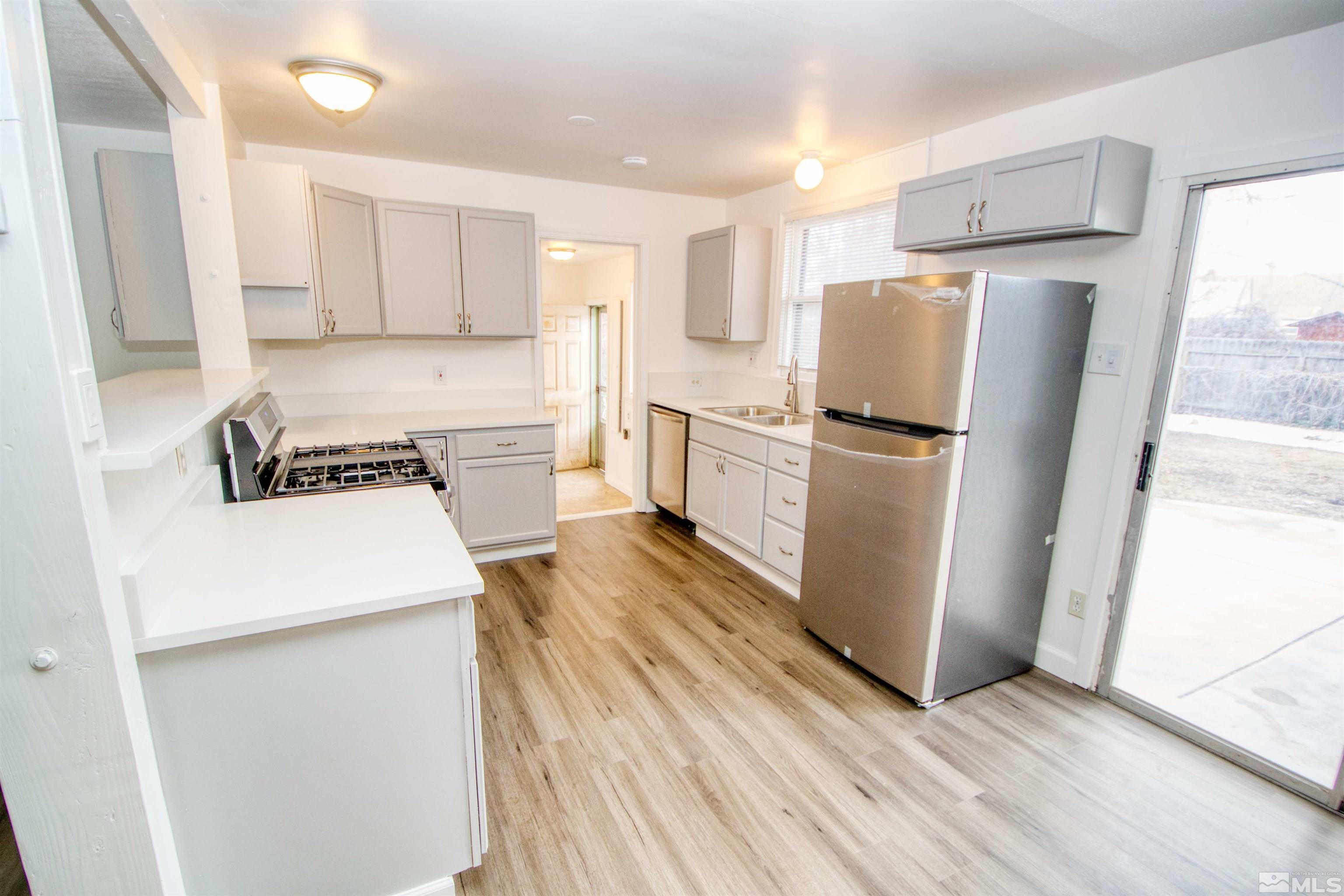 345 H Street Sparks, NV 89431 - Photo 5 of 17 a kitchen with a refrigerator a stove top oven and a counter space