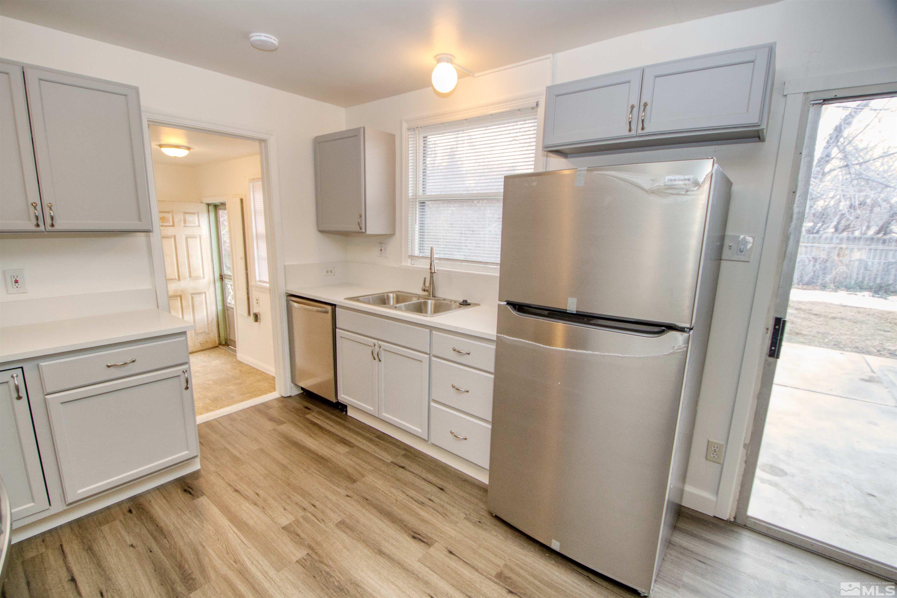 345 H Street Sparks, NV 89431 - Photo 7 of 17 a kitchen with white cabinets and white appliances