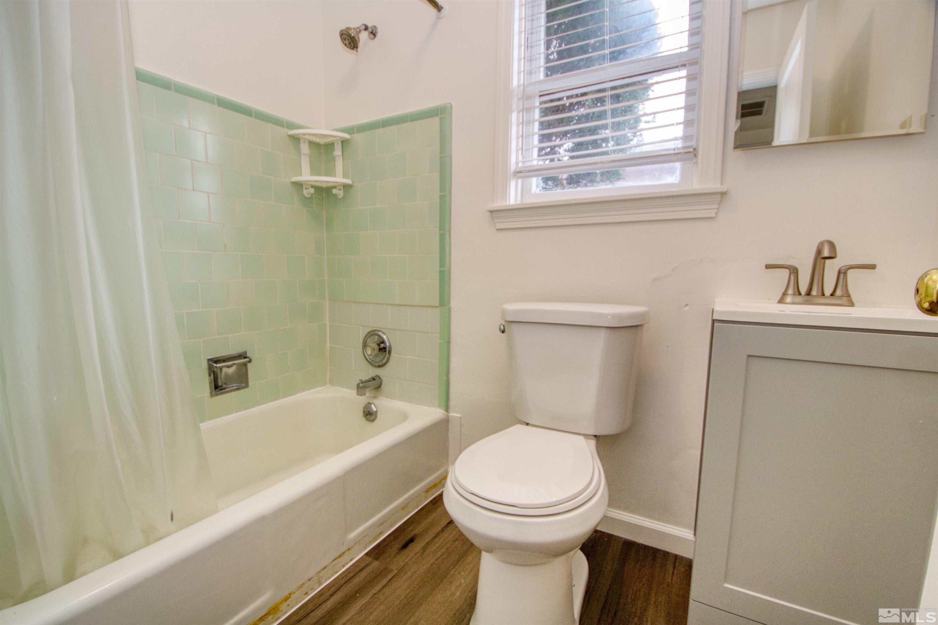345 H Street Sparks, NV 89431 - Photo 9 of 17 a bathroom with a toilet a sink a mirror and bathtub