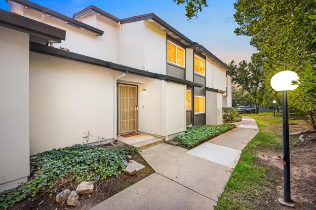 a front view of a house with a yard and fountain