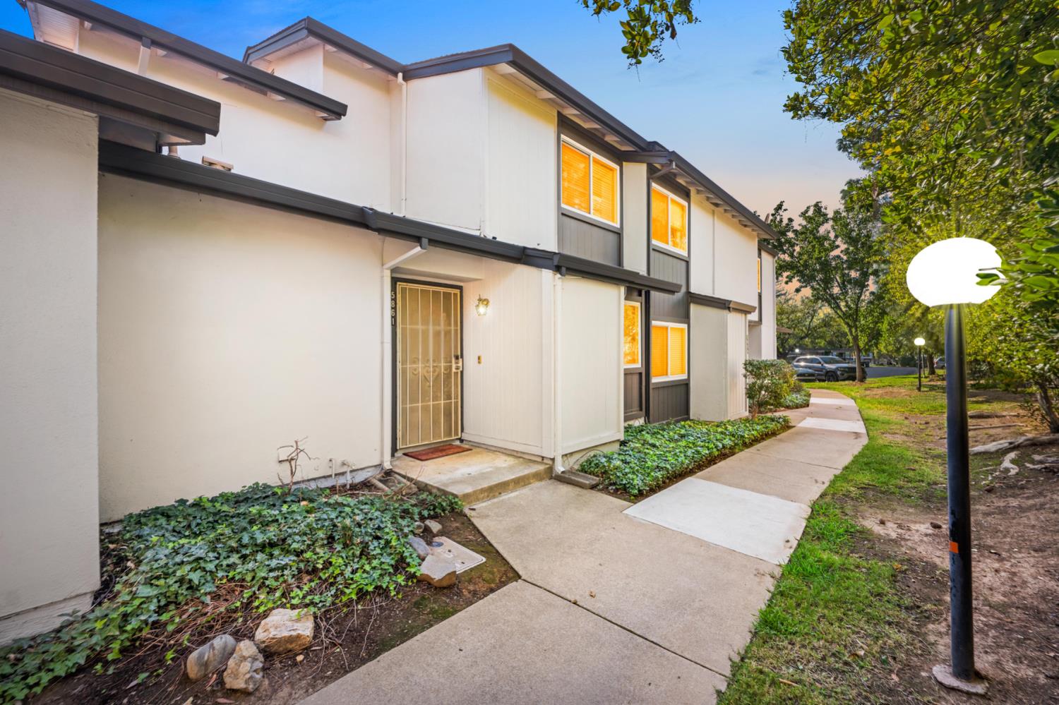a front view of a house with a yard and fountain