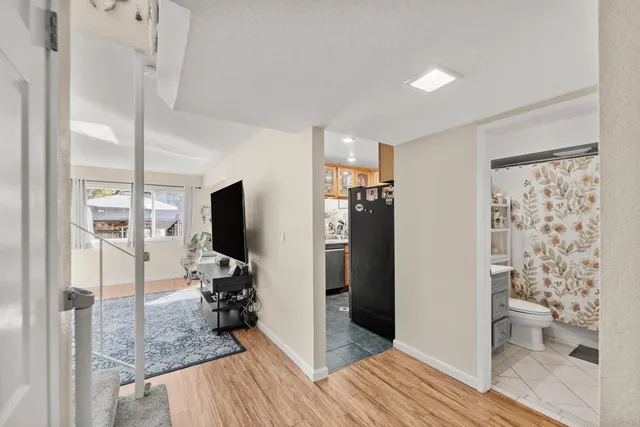 a view of a hallway with bathroom and wooden floor