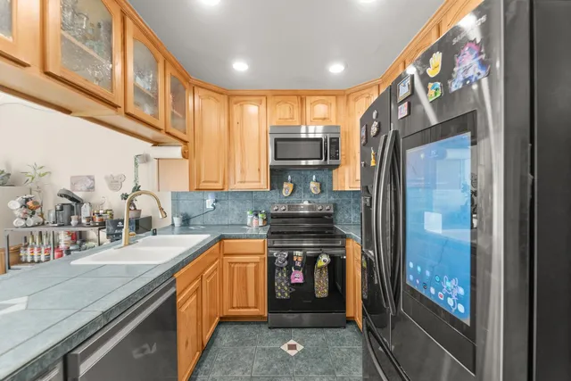 a kitchen with stainless steel appliances granite countertop a stove a sink and a refrigerator