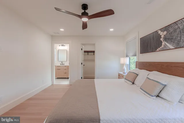a spacious bedroom with a bed and a ceiling fan