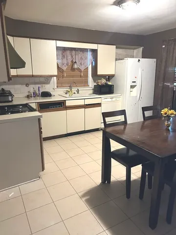 a kitchen with stainless steel appliances a table and chairs in it