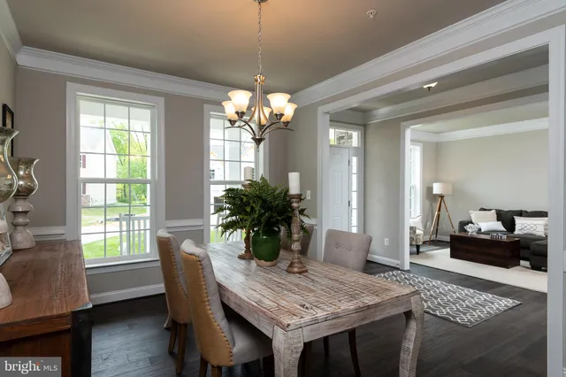a dining room with furniture a chandelier and wooden floor