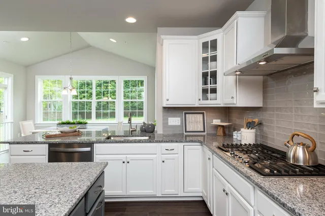 a kitchen with stainless steel appliances granite countertop a stove a sink and a microwave
