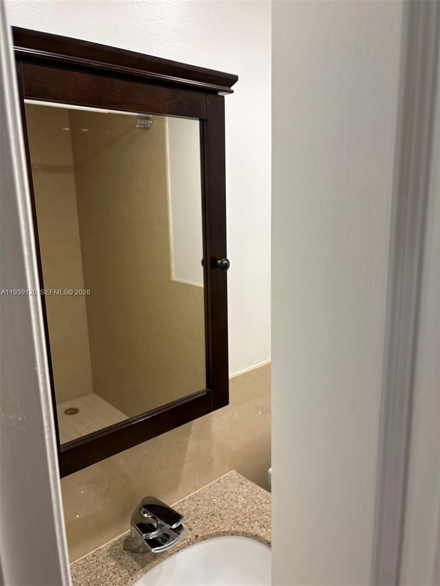 5555 Ludlam Road, Unit 105 South Miami, FL 33155 - Photo 10 of 29 a bathroom with a sink and a mirror