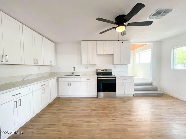 a kitchen with stainless steel appliances white cabinets and a sink