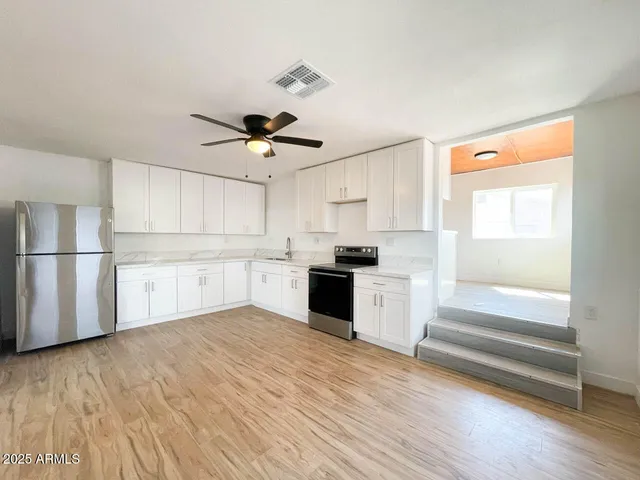 a view of kitchen with wooden floor and electronic appliances