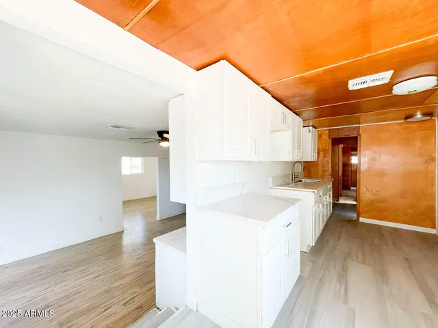 a view of a kitchen with wooden floor and a sink