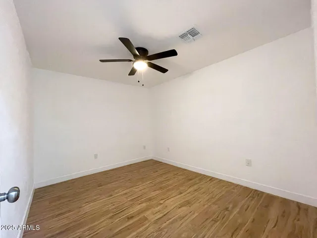 an empty room with a ceiling fan and a window
