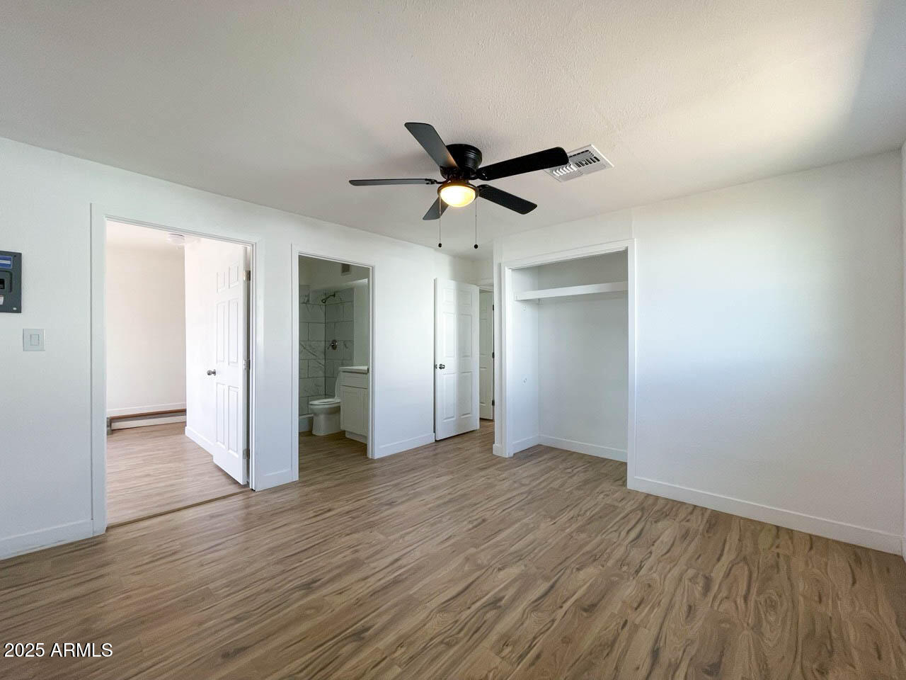 8125 East 5th Avenue Mesa, AZ 85208 - Photo 31 of 46 an empty room with wooden floor and a ceiling fan