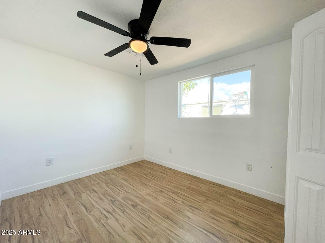 8125 East 5th Avenue Mesa, AZ 85208 - Photo 32 of 46 an empty room with wooden floor ceiling fan and windows
