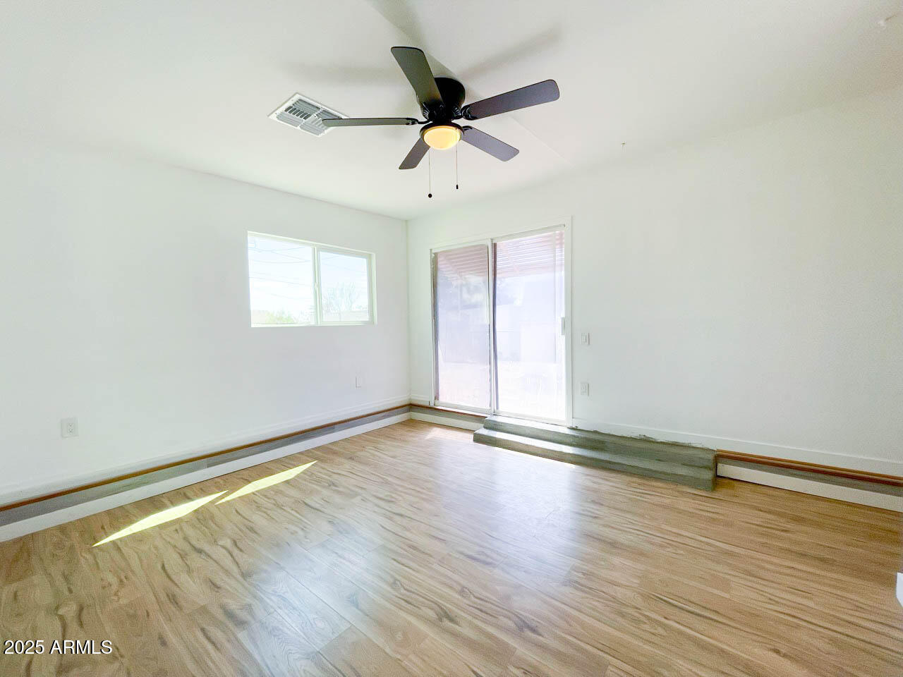 8125 East 5th Avenue Mesa, AZ 85208 - Photo 34 of 46 an empty room with wooden floor fan and windows