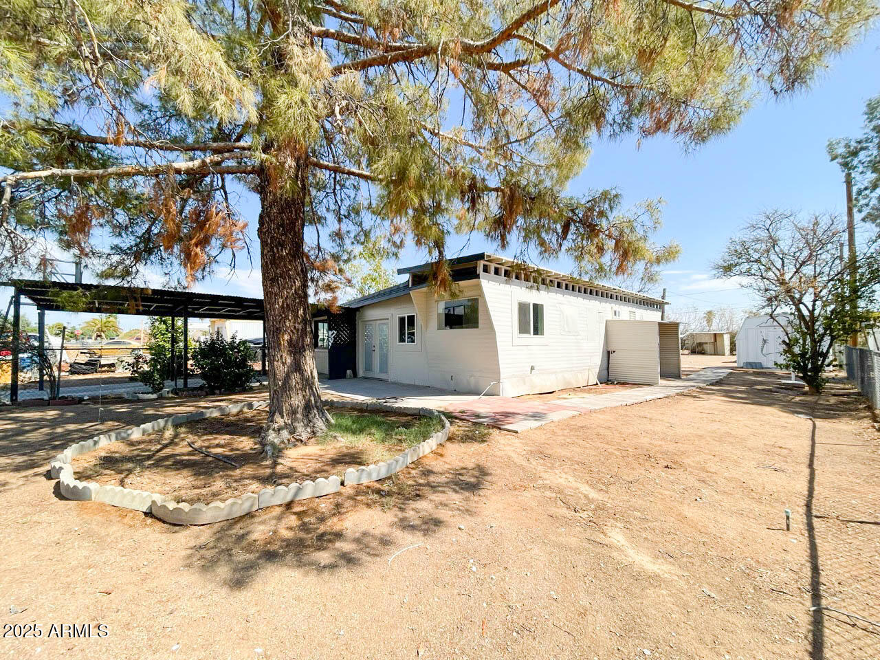 8125 East 5th Avenue Mesa, AZ 85208 - Photo 9 of 46 a view of a white house with a yard covered in snow