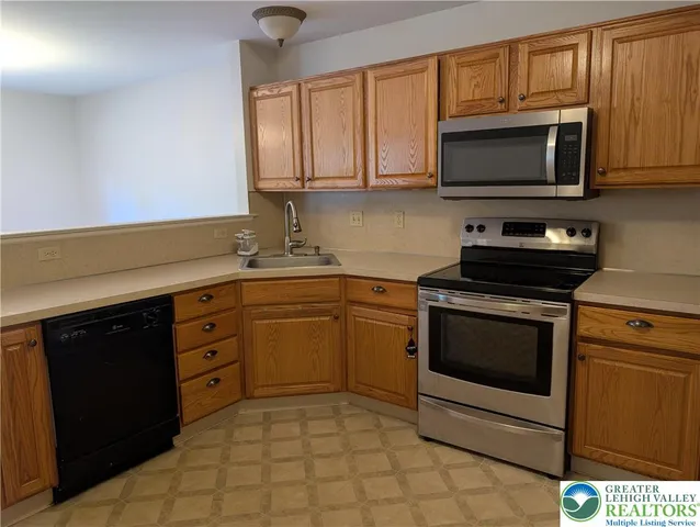 a kitchen with stainless steel appliances granite countertop a stove a microwave and a sink