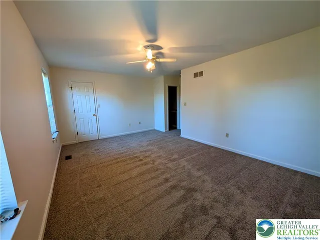 en empty room with windows and fan