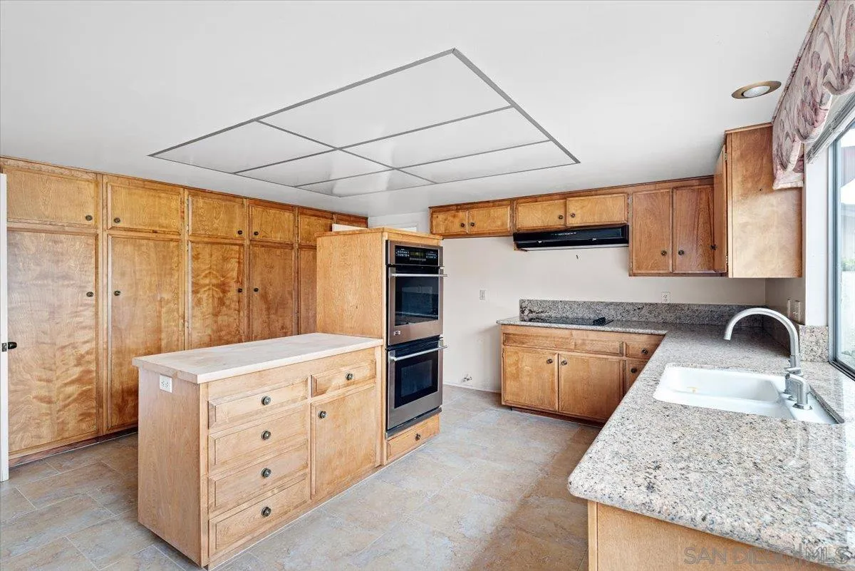 2257 Villa Maria Road North Claremont, CA 91711 - Photo 11 of 44 a kitchen with granite countertop a sink a stove and wooden cabinets