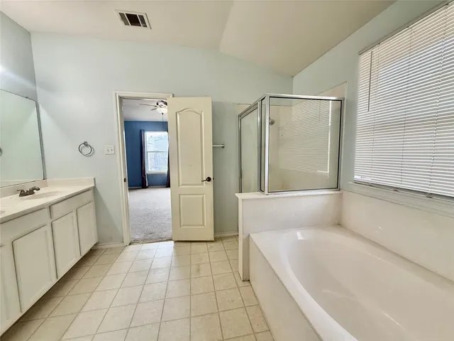 a bathroom with a tub shower and sink