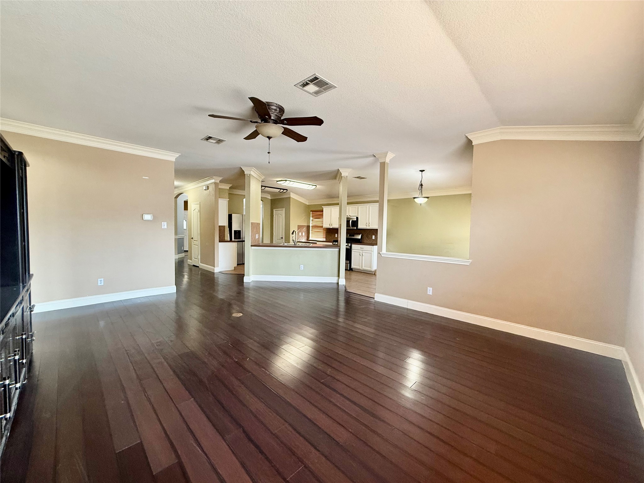 12820 Waynespur Lane Elgin, TX 78621 - Photo 8 of 26 a view of an empty room with wooden floor and a ceiling fan