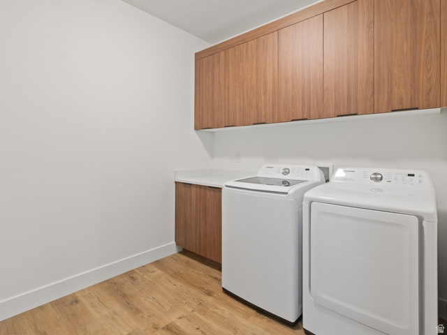130 East 7085th South, Unit 3 Midvale, UT 84047 - Photo 18 of 30 Laundry room with light wood-style flooring, independent washer and dryer, and cabinet space