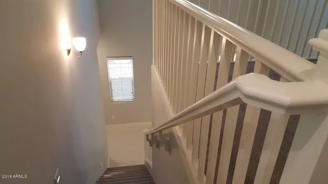 a view of staircase with railing and white walls