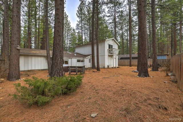 a view of a house with trees and sitting area