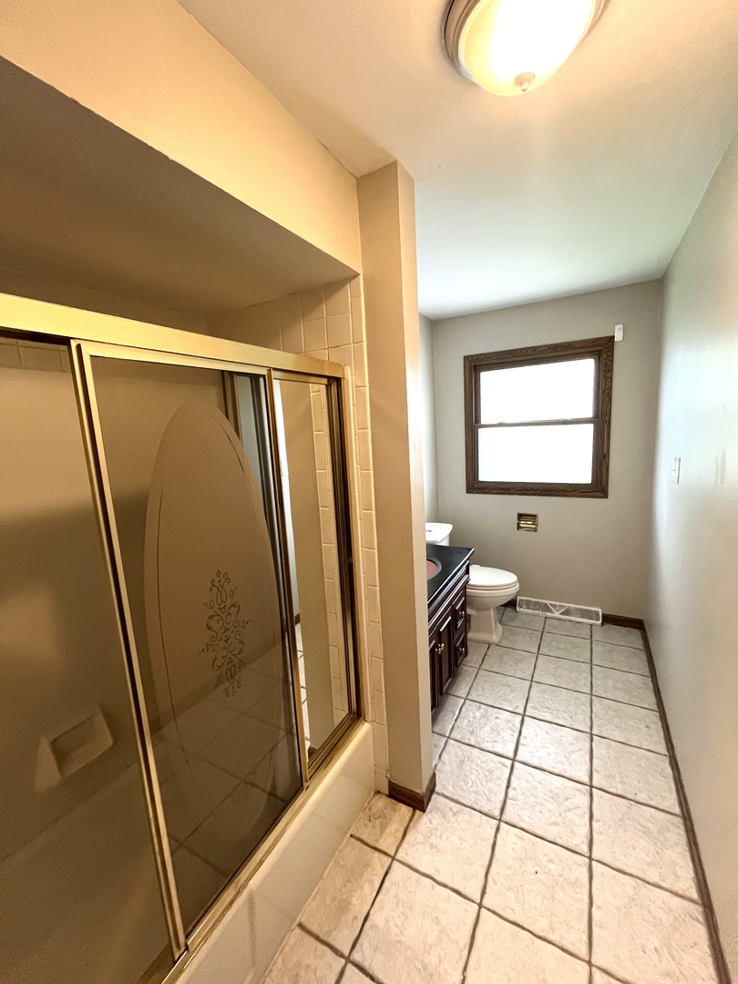 2843 193rd Street Lansing, IL 60438 - Photo 6 of 17 a bathroom with a glass door shower and a sink